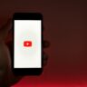 hand holding smartphone with internet access to youtube